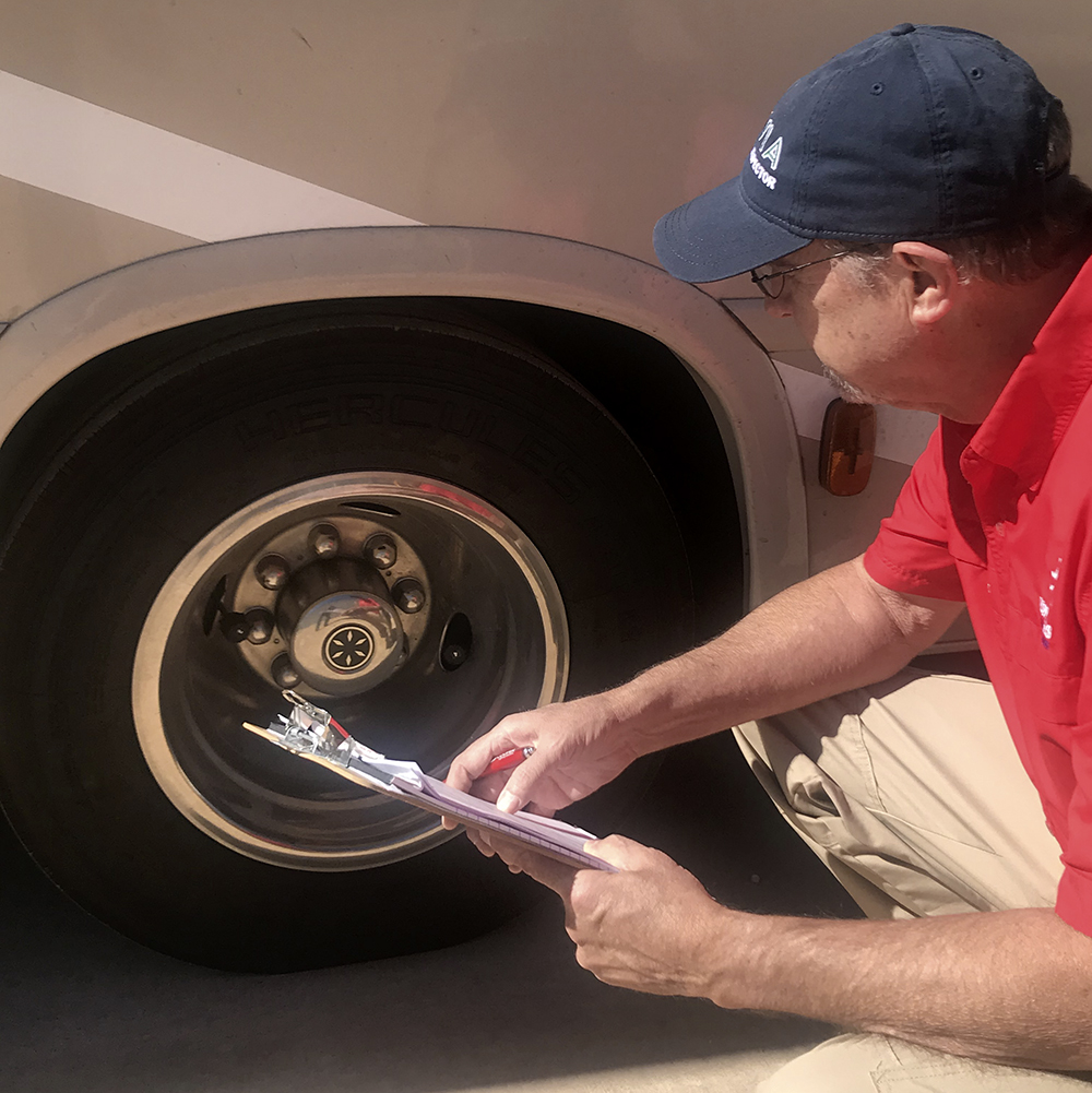 Wes Ward looking at a tire while preforming rv inspection services